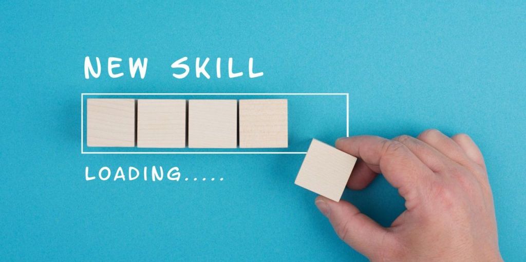 Progress bar with the words "new skill" above it and "loading.." underneath. A hand is adding a block to the progress bar to complete it.
